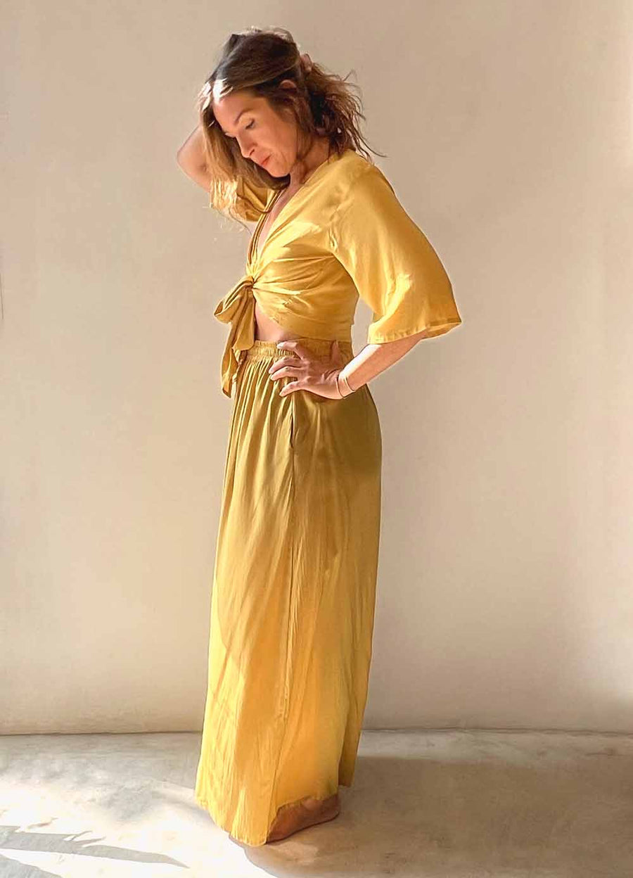Woman wearing a yellow outfit against a plain background