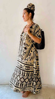 Woman wearing a black and white patterned dress against a plain background