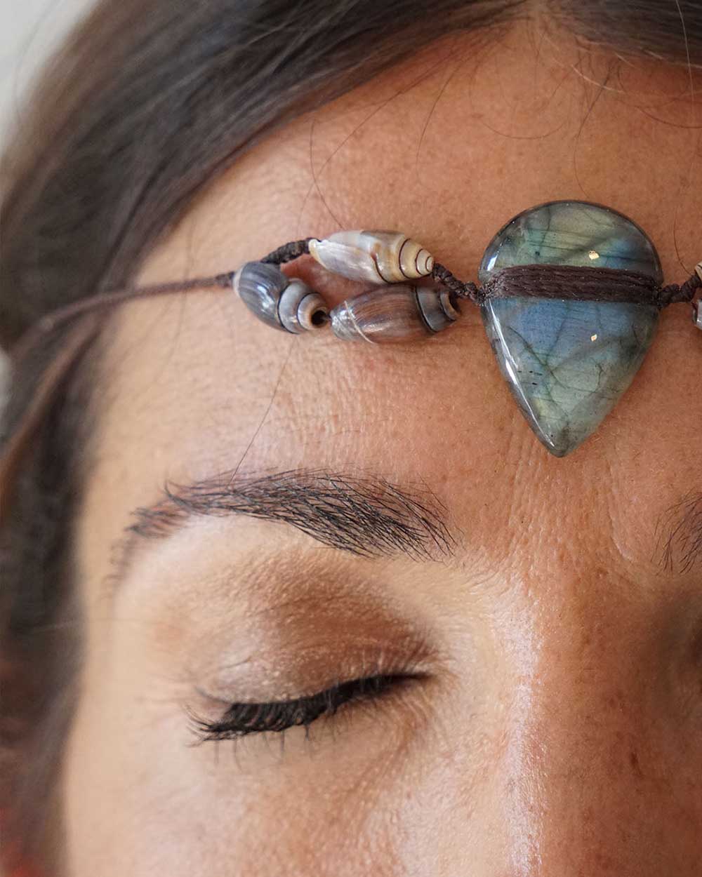 Close-up of a person wearing a headband with gemstones and beads.