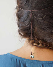 Person wearing a hair accessory with beads on a plain background