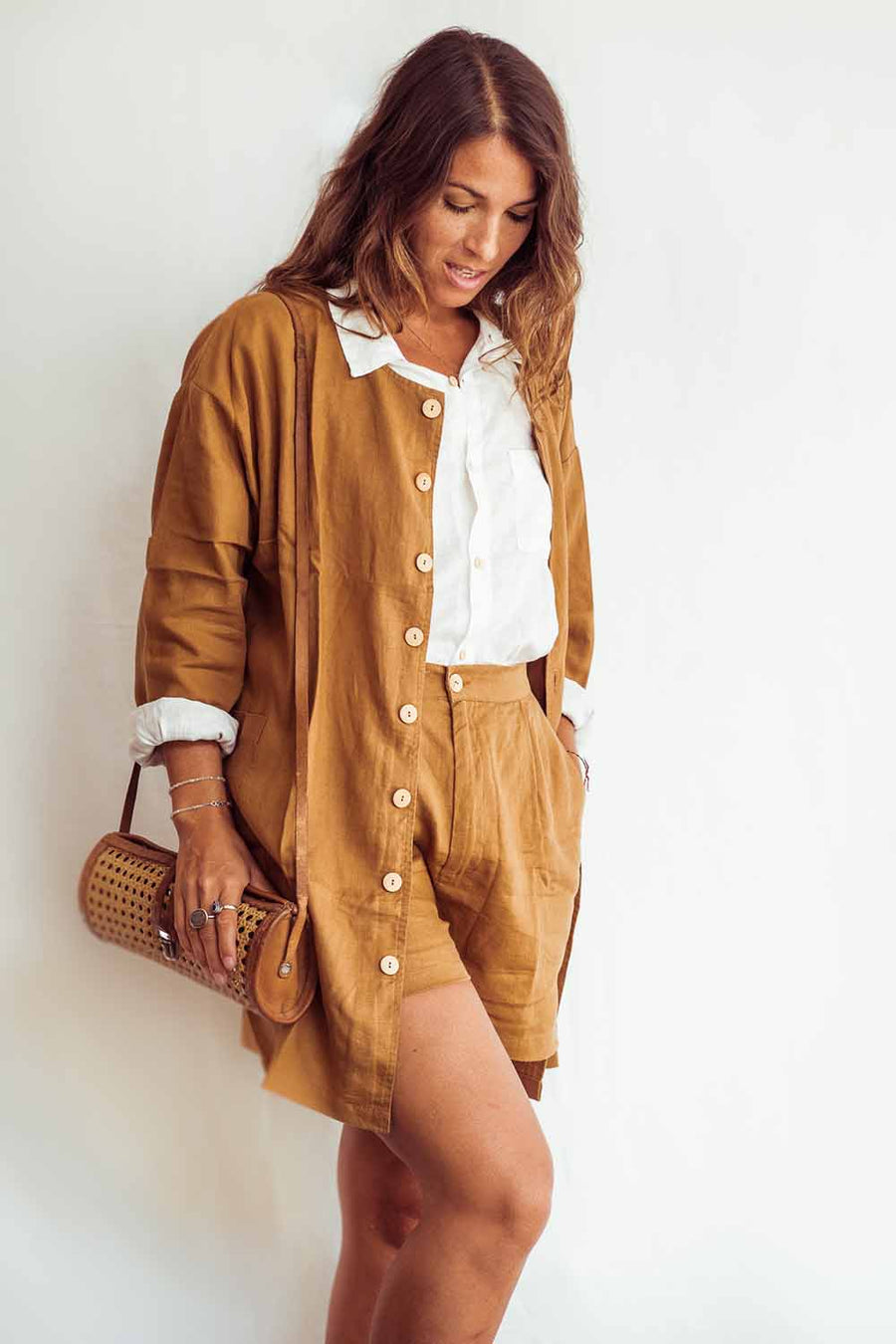 Woman wearing a mustard yellow outfit with a white background