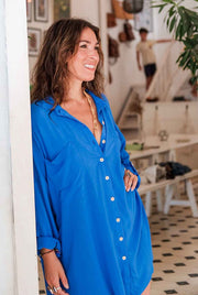 Woman wearing a blue shirt in an indoor setting with blurred background