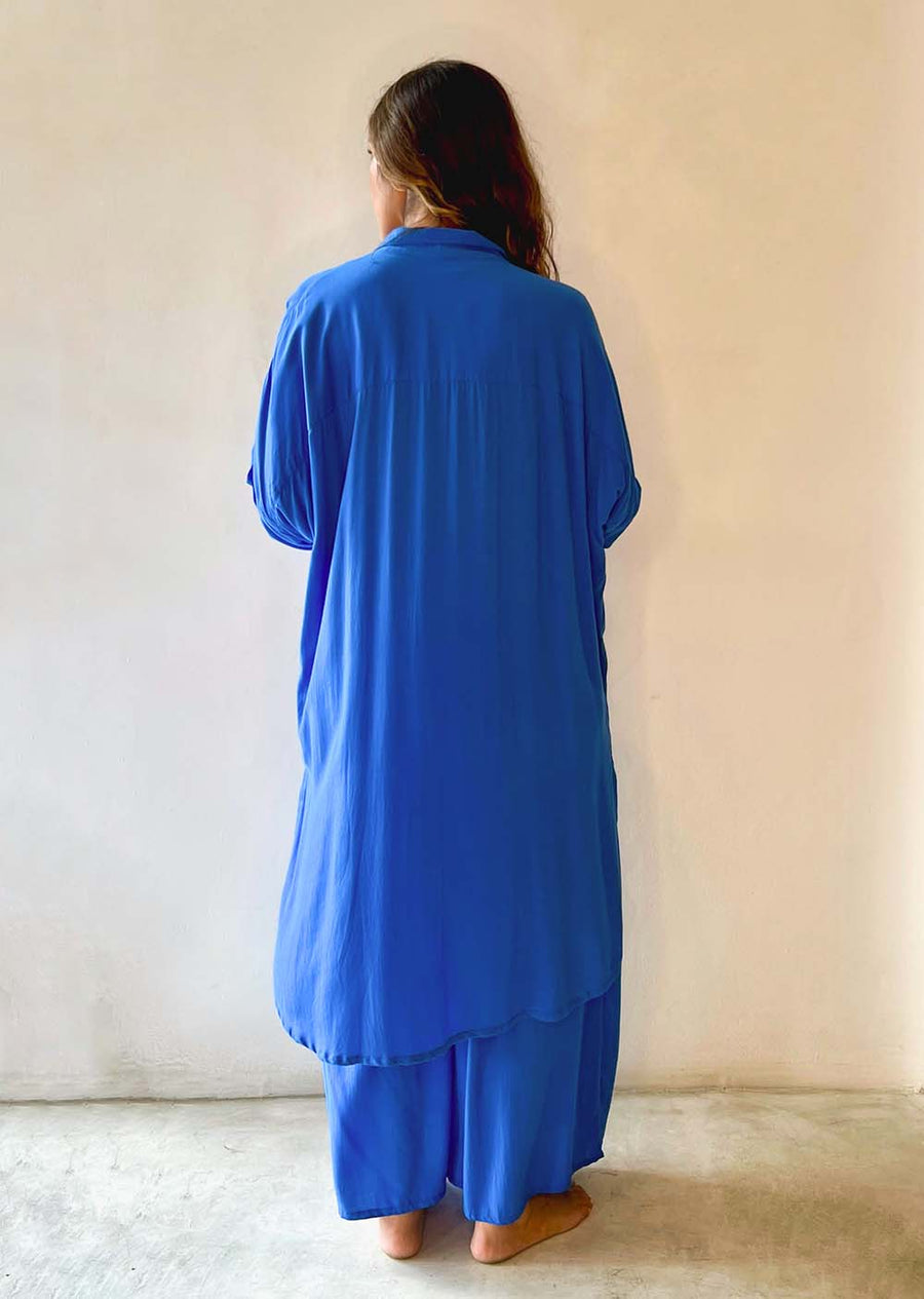 Person wearing a blue outfit against a plain background