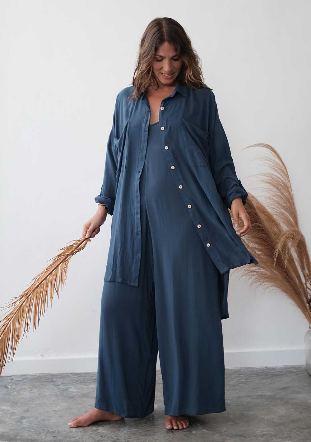 Woman wearing a blue outfit with a plain background