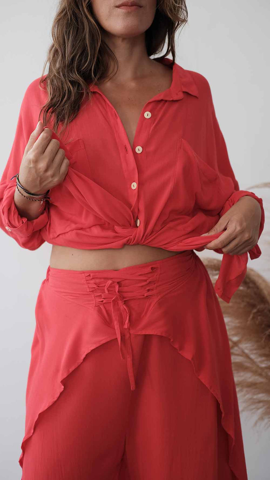Woman wearing a red outfit with a matching top and skirt against a neutral background