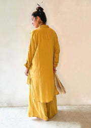 Person wearing a mustard yellow outfit against a plain background