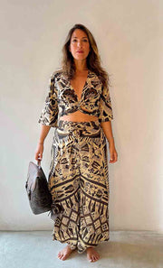 Woman wearing a patterned outfit with a plain background