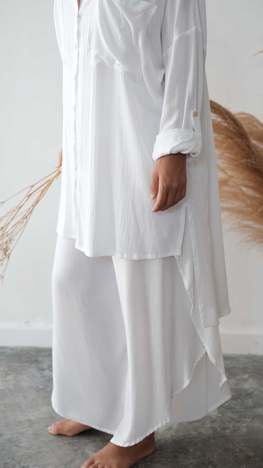 Person wearing a white outfit with a plain background