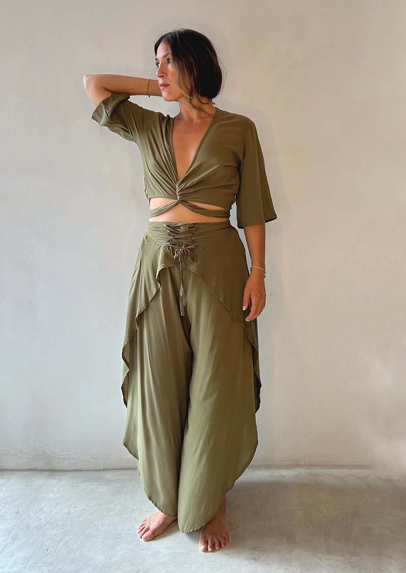 Woman wearing an olive green outfit with a plain background