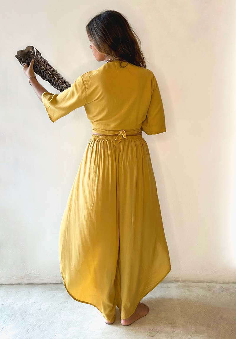 Woman wearing a yellow outfit against a plain background