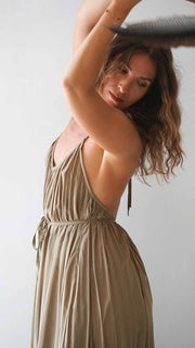 Woman wearing a beige dress against a plain background