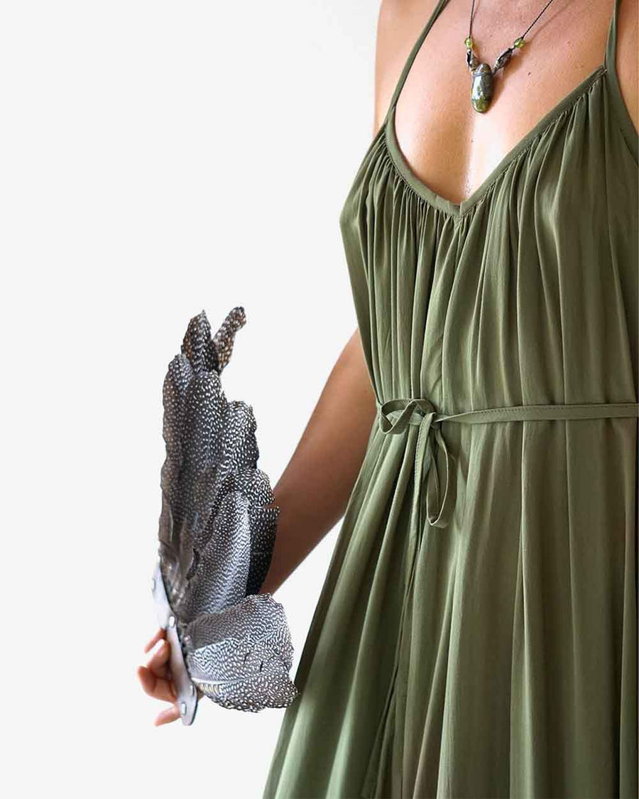 Person wearing a green dress holding a feather