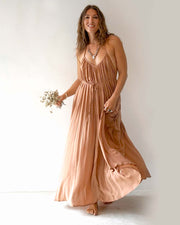 Woman wearing a long, flowing dress against a plain background