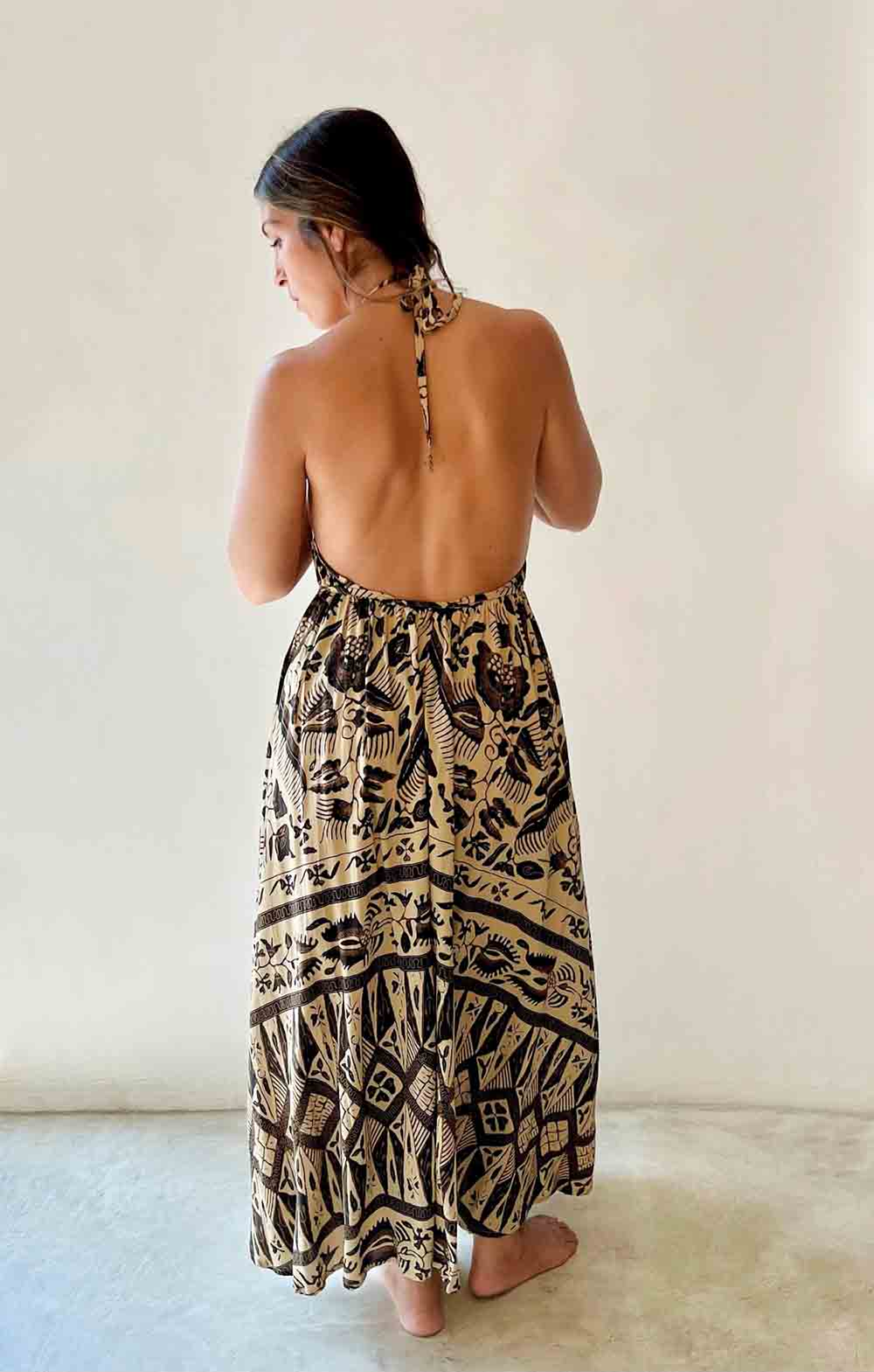 Woman wearing a patterned dress with a plain background