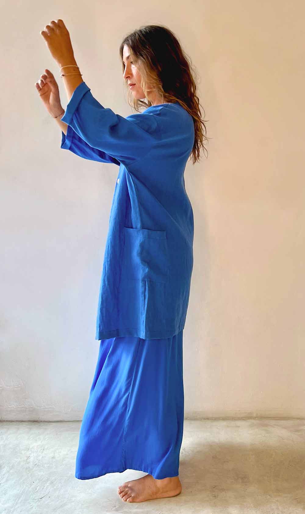 Person wearing a blue outfit against a plain background