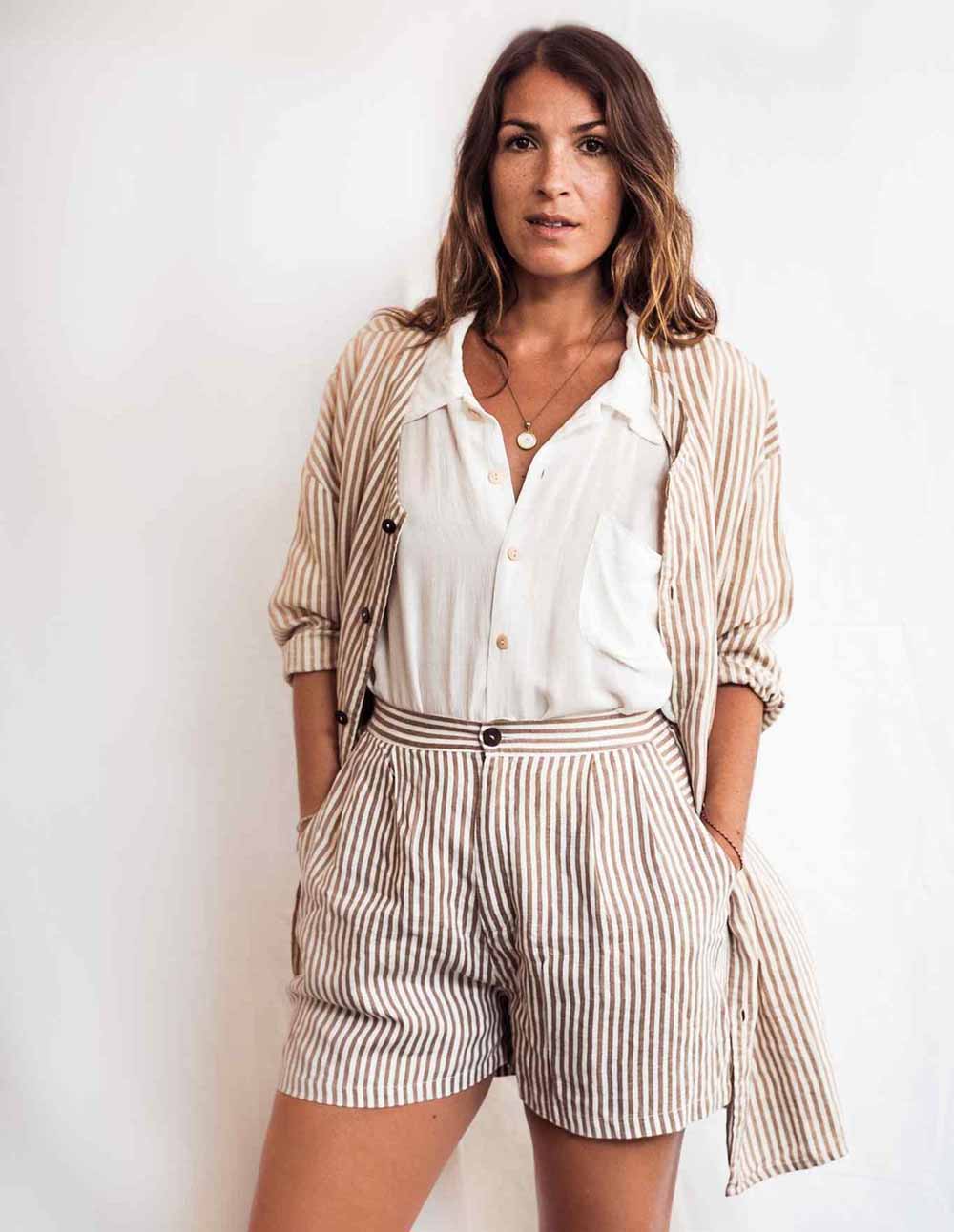 Woman wearing a striped shirt and shorts with a white background