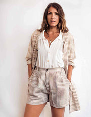 Woman wearing a striped shirt and shorts with a white background
