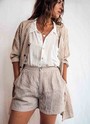 Woman wearing a striped shirt and shorts set against a plain background
