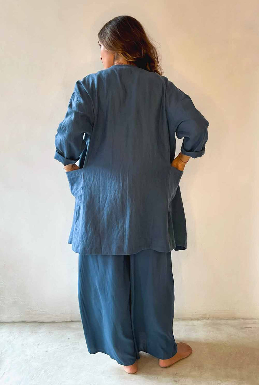 Person wearing a blue outfit standing against a plain background