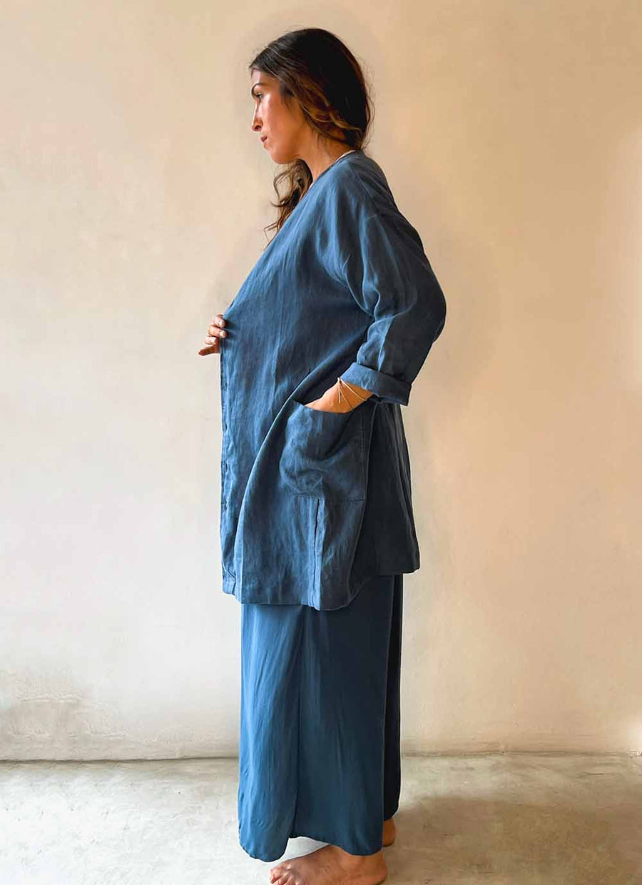 Woman wearing a blue outfit standing against a plain background
