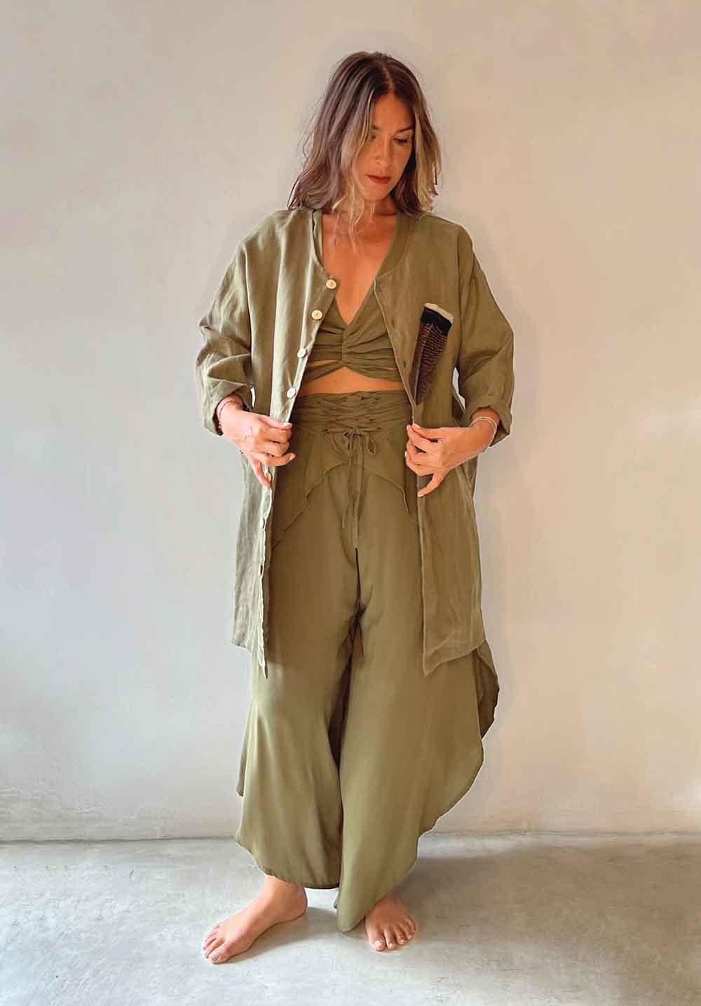Woman wearing an olive green outfit against a plain background
