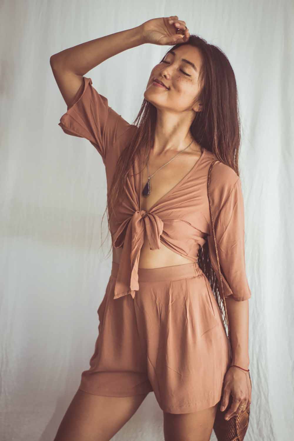 Woman wearing a brown outfit against a white background