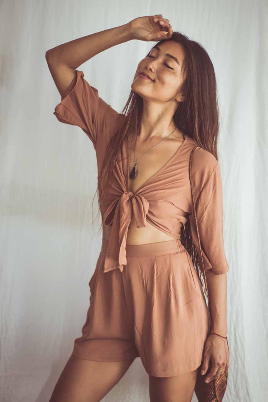 Woman wearing a brown outfit against a white background