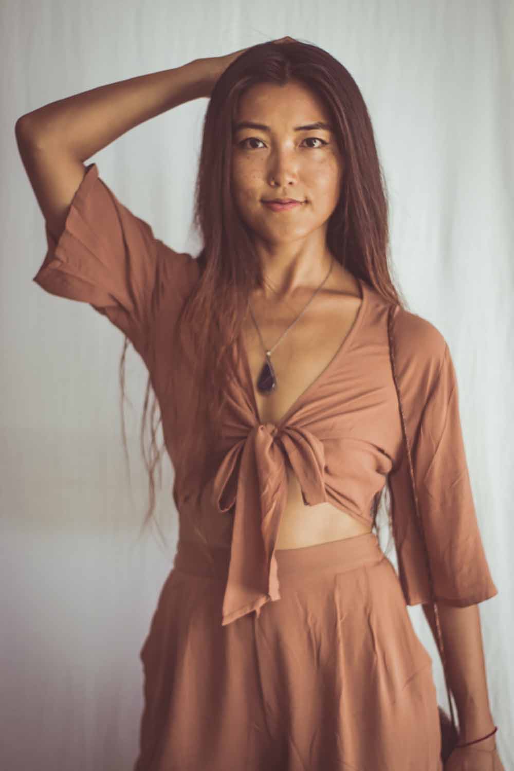 Woman wearing a brown outfit with a plain background
