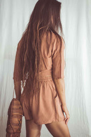 Woman wearing a brown dress with a plain white background