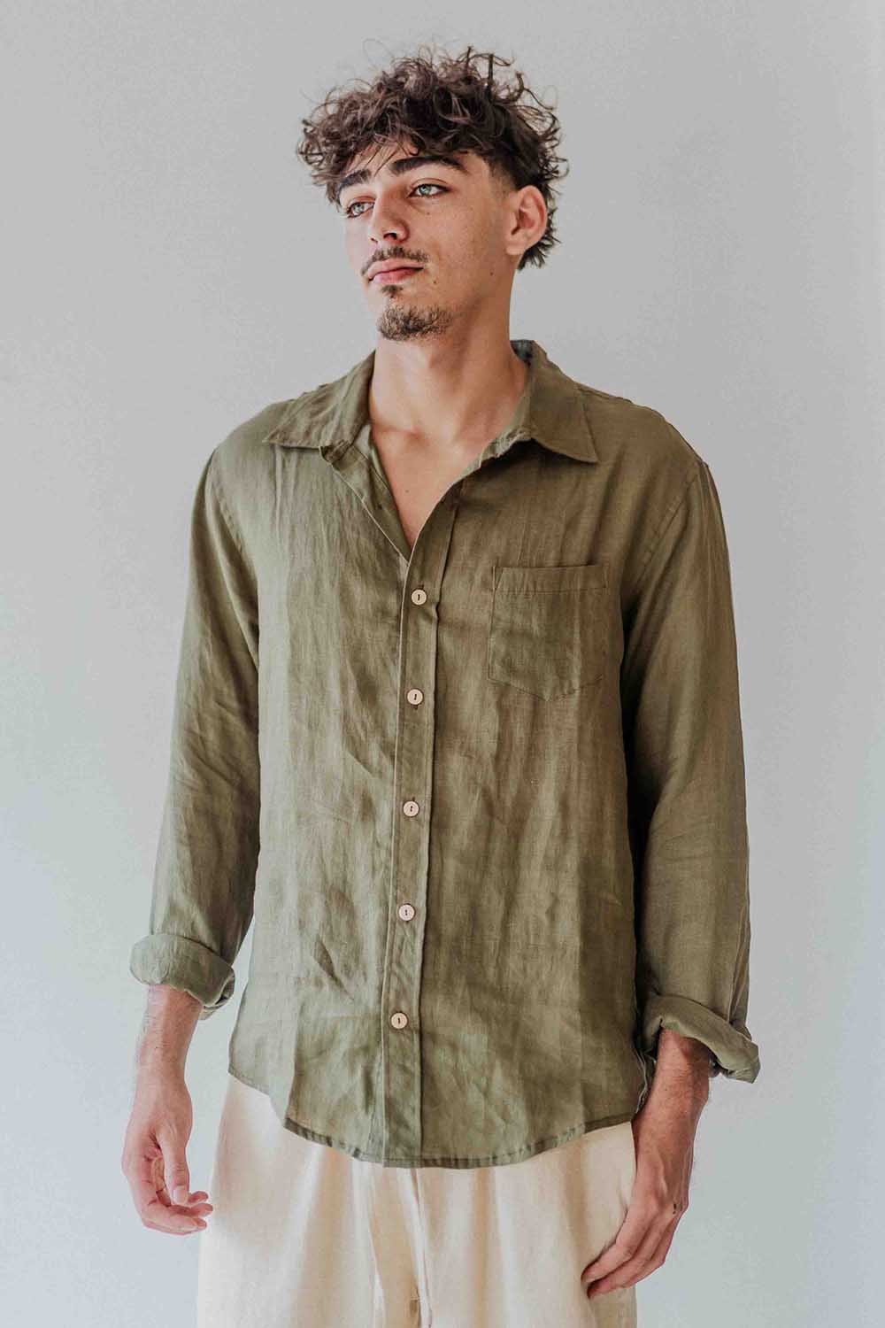 Man wearing an olive green shirt against a plain background
