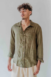 Man wearing an olive green shirt against a plain background