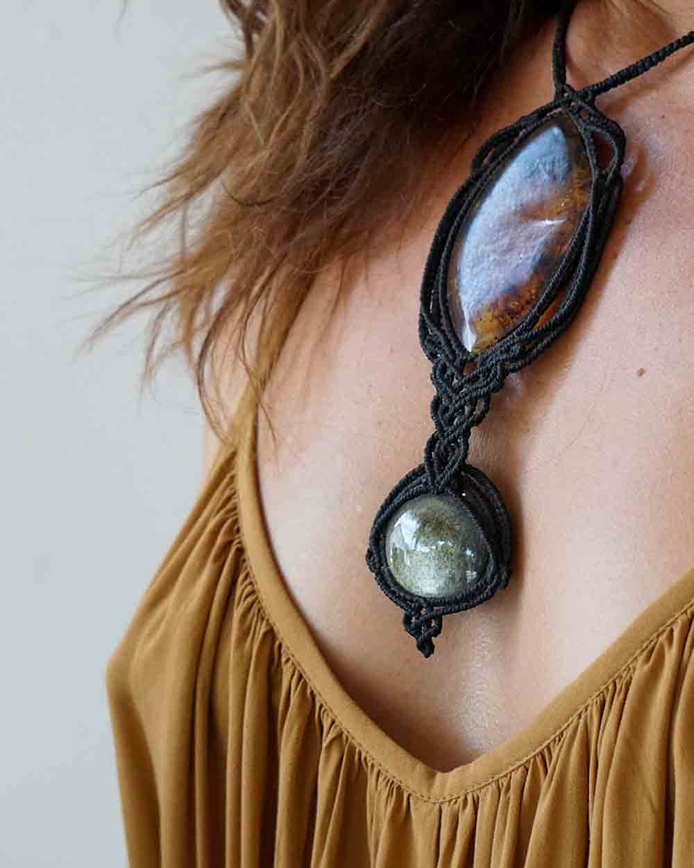 Necklace with stone pendant worn by a person against a neutral background