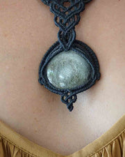 Necklace with a stone pendant on a person's neck