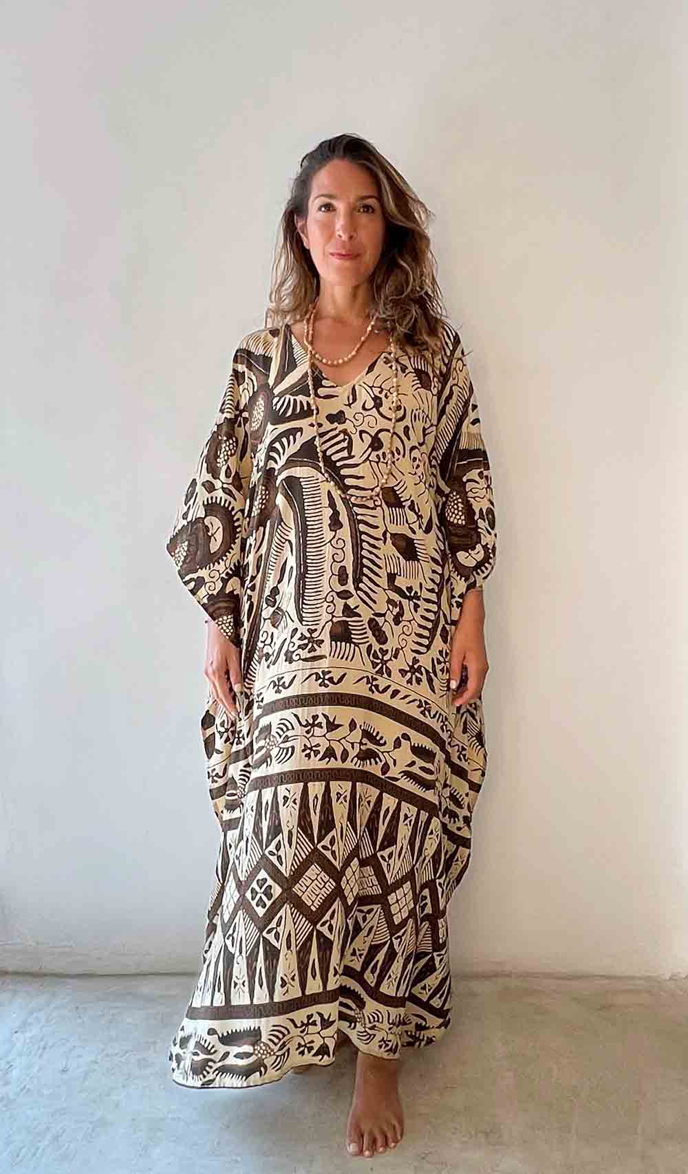Woman wearing a patterned dress against a plain background