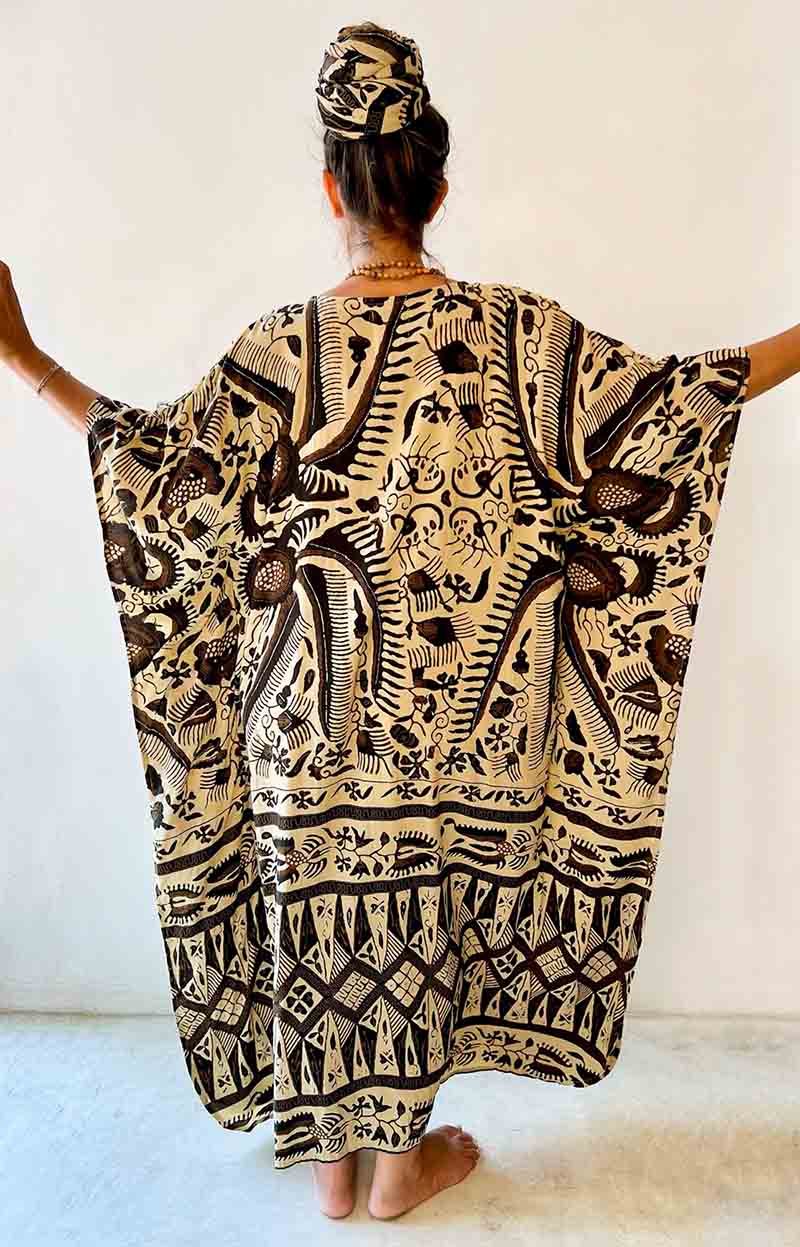 Person wearing a black and white patterned dress with a plain background