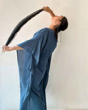 Woman in a blue saree holding a black hairbrush against a white background