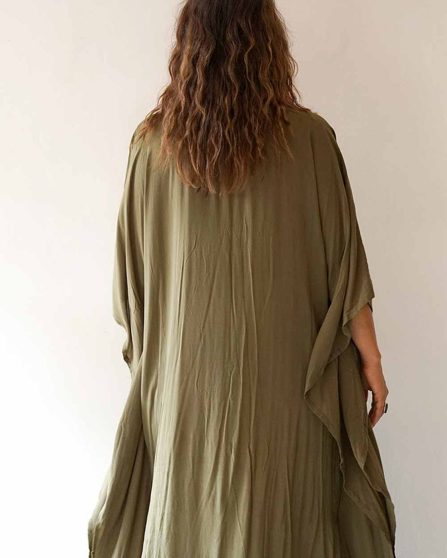 Person wearing a green dress with a plain background