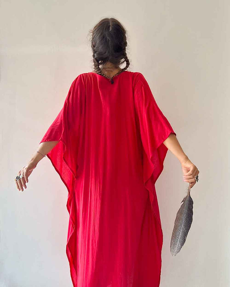 Person wearing a red dress holding a black fan against a plain background