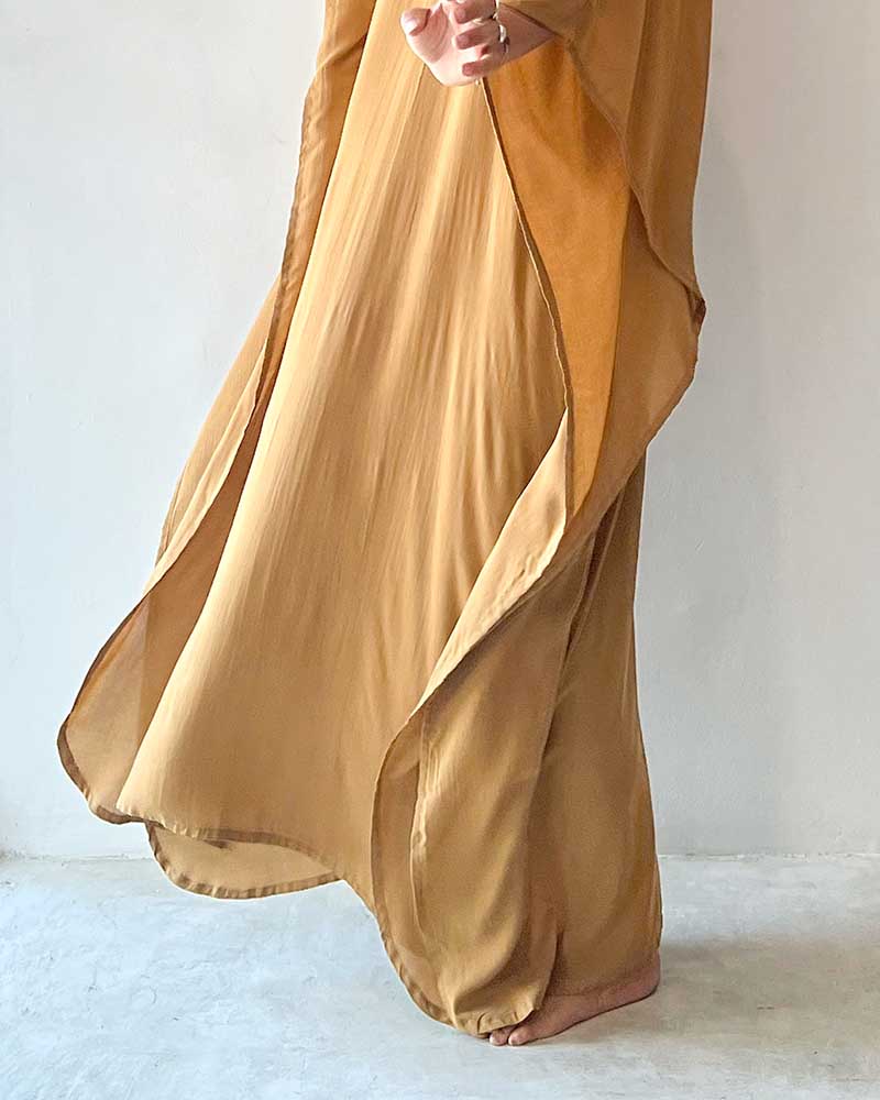Mustard yellow outfit with a long, flowing top and wide-leg pants on a light background