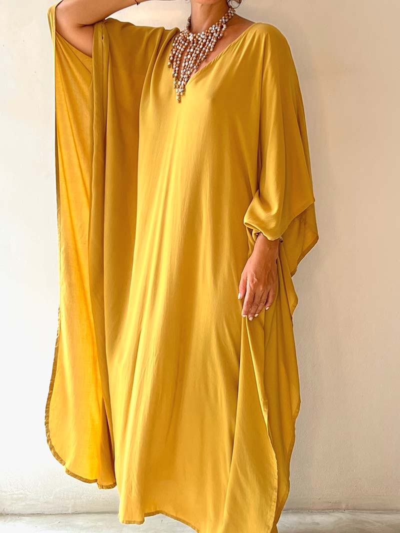 Yellow dress worn by a person against a plain background