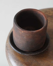 Wooden cup and saucer set on a wooden surface