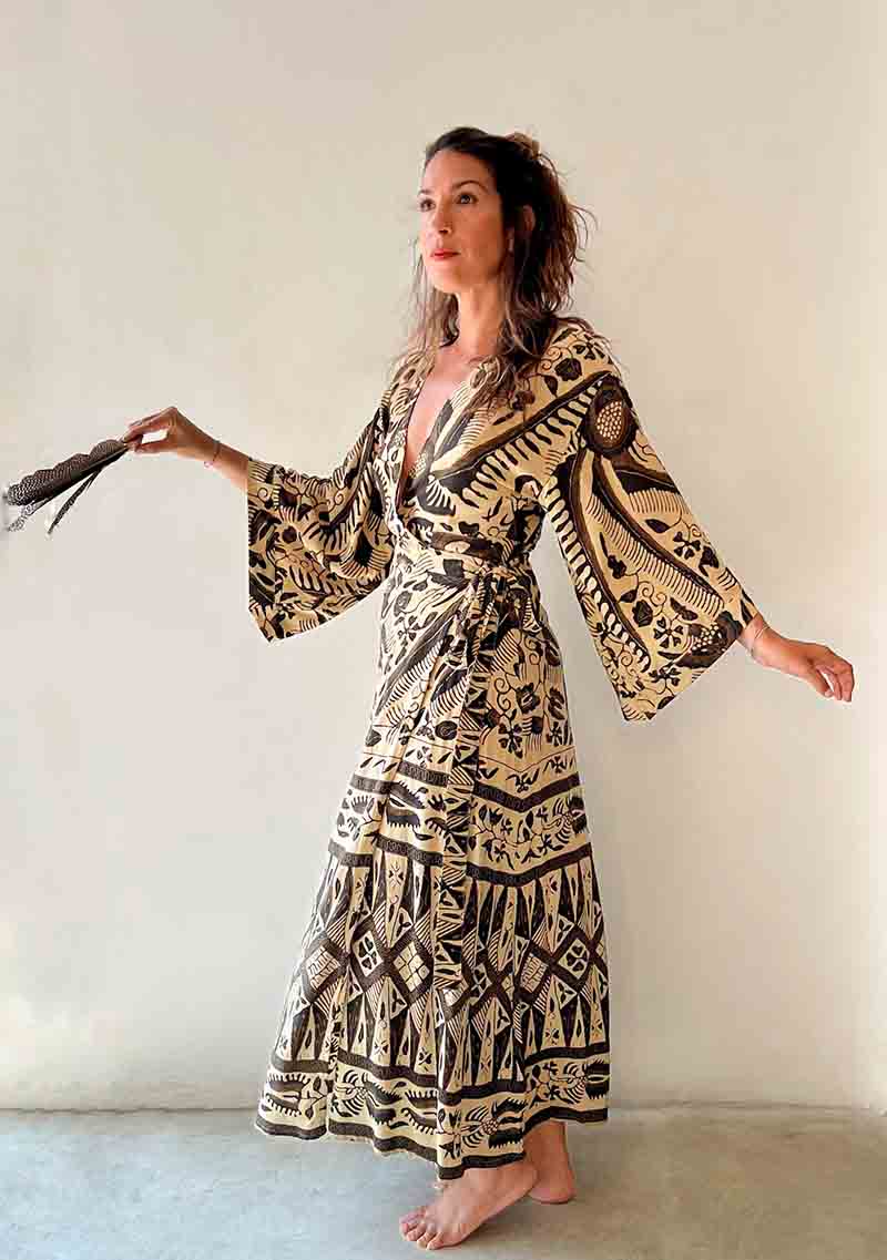 Woman wearing a patterned dress against a plain background