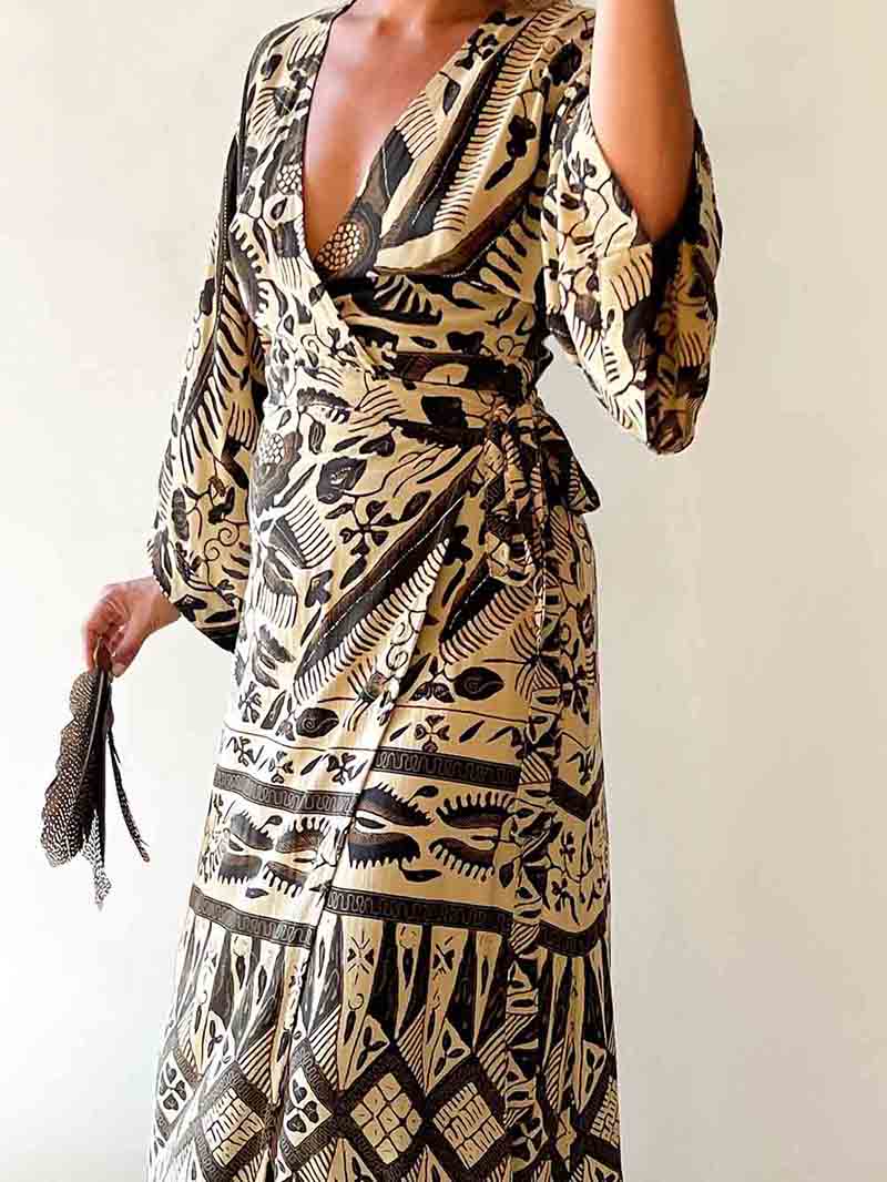 Person wearing a patterned dress with a plain background
