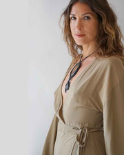 Woman wearing a beige dress with a plain background
