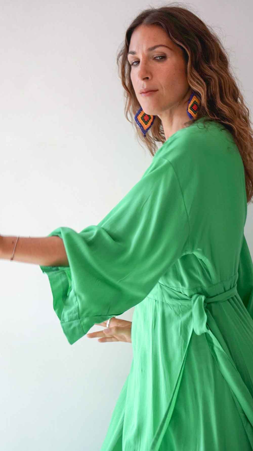 Woman wearing a green dress with a plain background