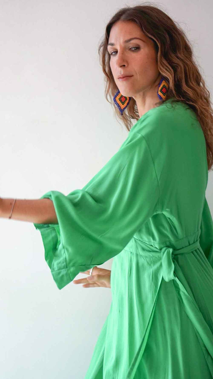 Woman wearing a green dress with a plain background