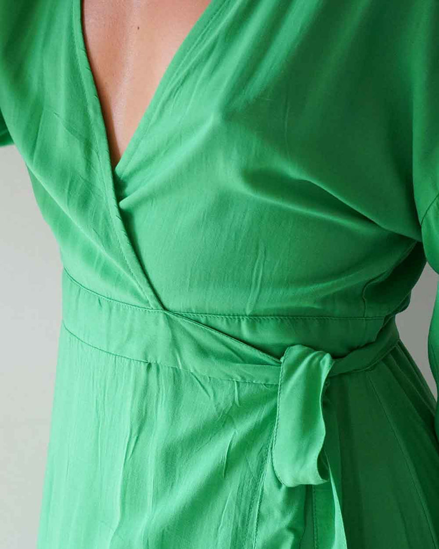 Green dress with a belt on a plain background