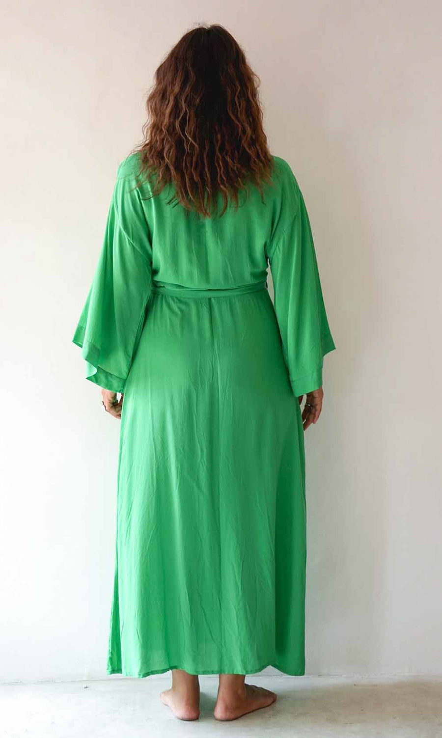 Person wearing a green robe against a white background