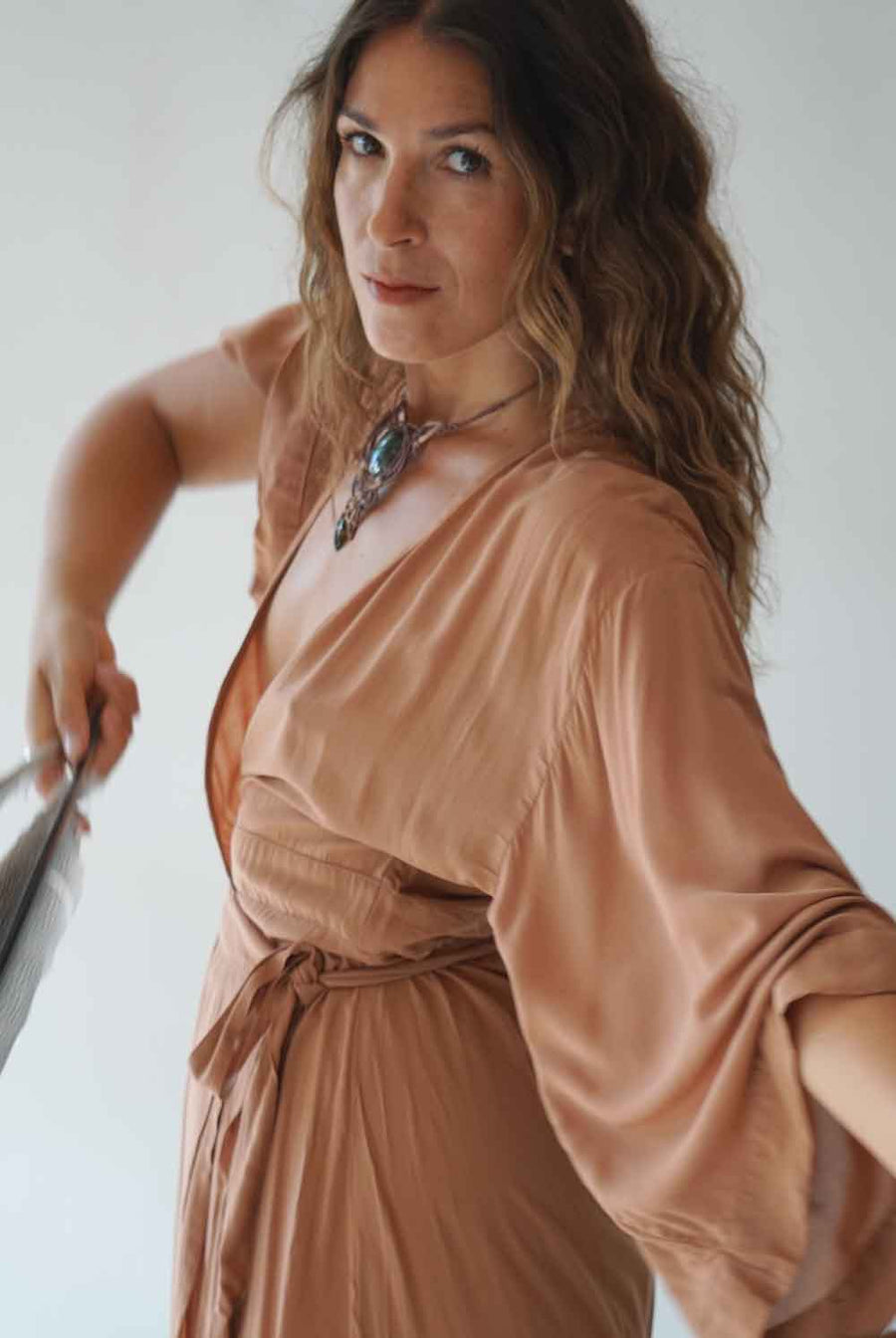 Woman wearing a brown dress with a neutral background