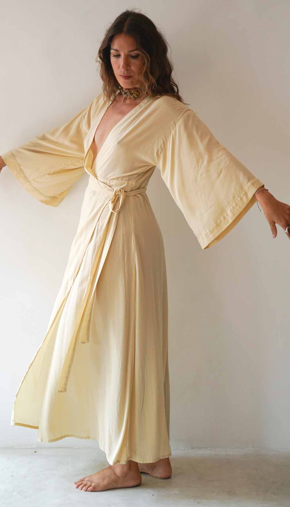 Woman wearing a beige kimono-style dress against a plain background